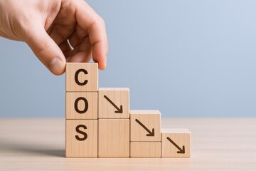 Cost Optimization Strategy: Hand Placing Wooden Blocks with Downward Arrows Depicting Reduced Expenses