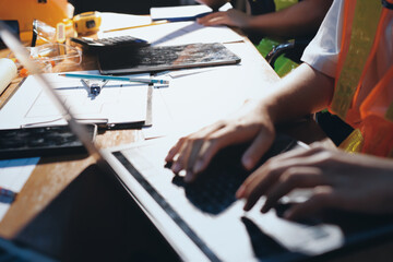 Closeup of team of industrial engineers meeting analyze machinery blueprints consult project on table in manufacturing factory. Working in manufacturing plant or production plant.