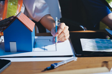 Closeup of team of industrial engineers meeting analyze machinery blueprints consult project on...