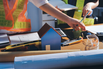 Closeup of team of industrial engineers meeting analyze machinery blueprints consult project on table in manufacturing factory. Working in manufacturing plant or production plant.
