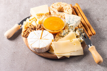 Wooden charcuterie board with various cheese and olives. Brie. Camembert. Parmesan, feta, blue cheese. Italian, French cheese