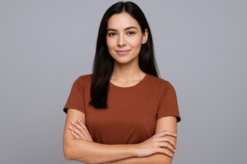 Fototapeta premium Confident Young Woman Portrait with Arms Crossed, Smiling on Gray Background