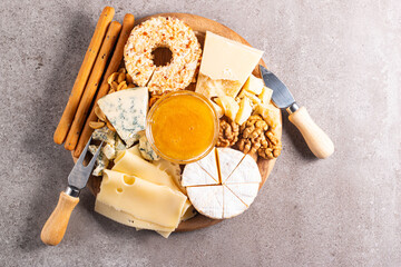 Wooden charcuterie board with various cheese and olives. Brie. Camembert. Parmesan, feta, blue cheese. Italian, French cheese