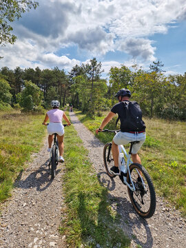 Couple cycling on forest trail in Karst Slovenia