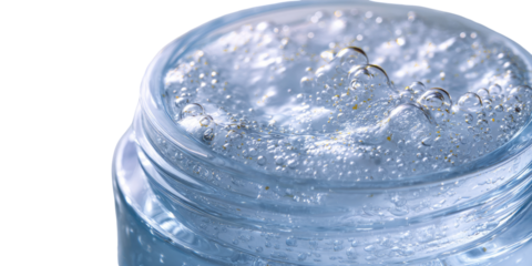 Clear gel cream in a glass jar, bubbling with small bubbles and golden specks