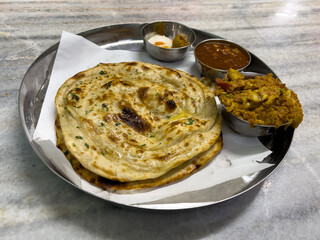 Traditional Punjabi meal with paratha served with vegetable curry and lentils, Amritsar, India.