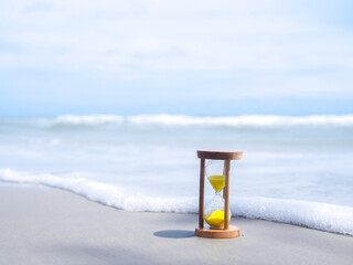 Hourglass on the beach. The concept about countdown to Summer, Travel, Vacation and Relaxation.