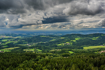 Weite Landschaft mit bewölktem Himmel und sanften Hügeln in einer ruhigen Region im Sommer