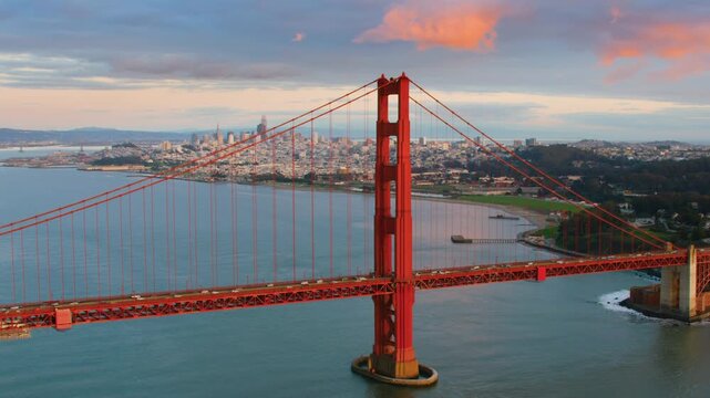 Iconic Golden Gate Bridge In San Francisco Captured At Sunset With Vibrant Orange Towers And Expansive City Skyline In The Background Overlooking The Bay And Rolling Hills