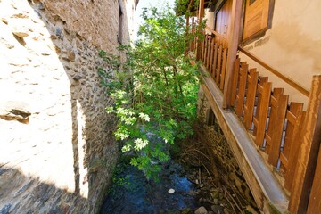 small river with green vegetation between the houses of Aramaio in Ibarra, Basque Country