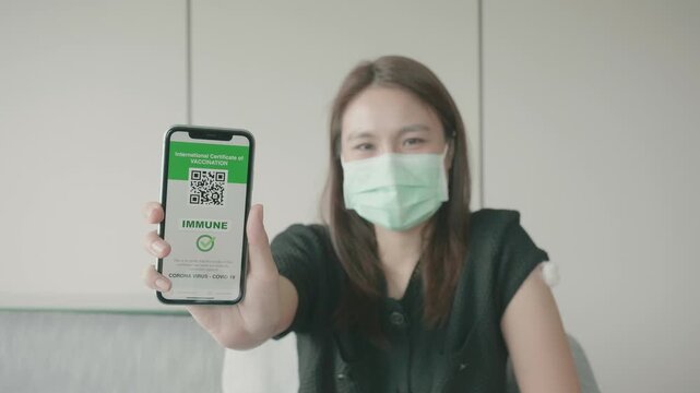 A woman in a face mask proudly displays her vaccination certificate on her smartphone, symbolizing health and safety in the post-pandemic world.