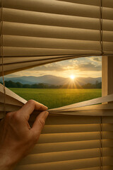 Hand opening window blinds with warm sunlight