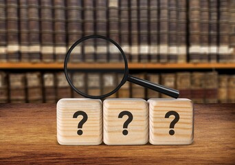 Magnifying glass and question mark on wood cubes
