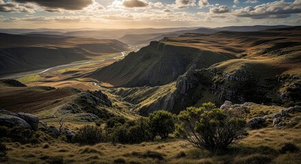 Fototapeta premium Dramatic Golden Hour Landscape with Winding River Through Rolling Hills and Valleys