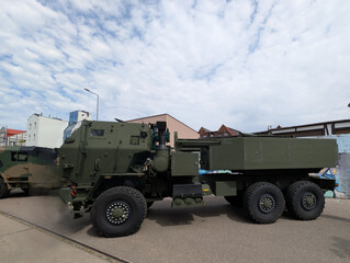 Fototapeta premium Military transport vehicle positioned on urban street during daytime under cloudy sky
