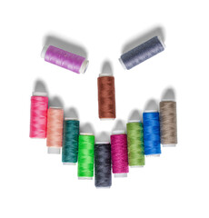 A stylized face with an evil smile made from spools of colorful thread. On a transparent background with a shadow.