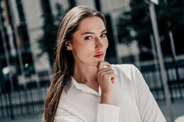 Charming young businesswoman in urban setting expressing professionalism and elegance wearing...