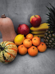 Fresh fruit and vegetables creating a colorful still life on grey background