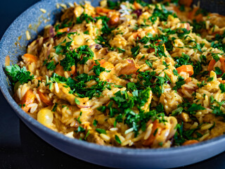 Chicken curry with vegetables and white rice in frying pan on induction cooker