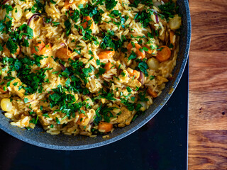 Chicken curry with vegetables and white rice in frying pan on induction cooker