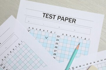 Answer sheets and pencil on wooden table, flat lay. Student passing exam