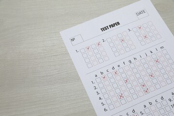 Answer sheet on wooden table, above view. Student passing exam