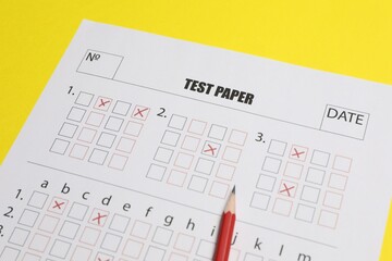 Answer sheet and pencil on yellow background, closeup. Student passing exam