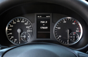 Close-up of a car dashboard cluster with analog speedometer, tachometer, fuel and temperature...