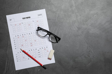 Student passing exam. Answer sheet, glasses, pencil and eraser on gray textured table, flat lay....