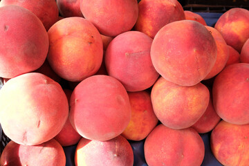 Fresh peaches stacked vibrantly at a summer farmer's market
