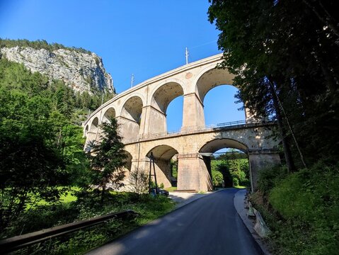 Summer landscape featuring the iconic Semmering railway viaduct in Austria, photographed on a bright sunny day against a clear blue sky. 