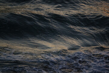 Calm ocean with small waves at sunset