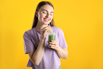 Woman with refreshing drink and straw on orange background