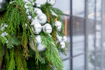 Silver baubles on evergreen branches decorates winter holiday scene