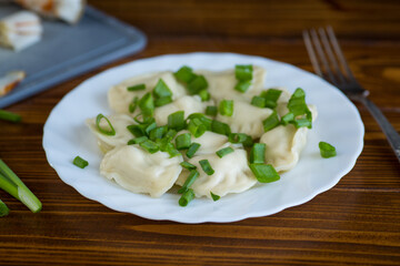 Appetizing dumplings with potatoes and onions on a rustic table