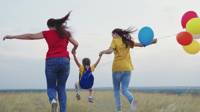 running family park. happy mother child kid run teamwork. colorful air balloons fly wind. mom girl daughter travel nature. inflated helium balloons festive mood. holiday happy family. children dream