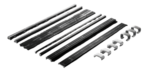 Assorted dark gray/black metal strips and clips.  Layered components, various shapes and sizes, suggesting a system or set of parts for a mechanical device