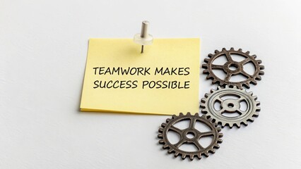 Yellow Sticky Note with Teamwork Quote and Gear Elements on Table