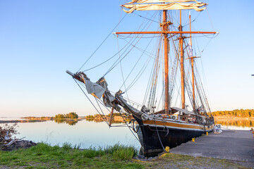 Obraz premium Vintage wooden boat moored at a pier in Finland, Baltic Sea. Rustic maritime scene, traditional craftsmanship, peaceful harbor, connection with northern coastal culture
