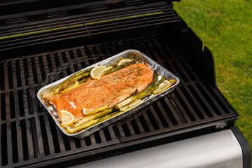 Grilled salmon fillets and asparagus sizzling on a barbecue grill