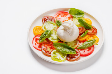 Fresh burrata served on slices of colorful tomatoes
