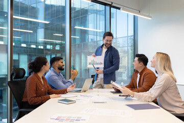 Marketing manager showing growth chart to his team during a meeting