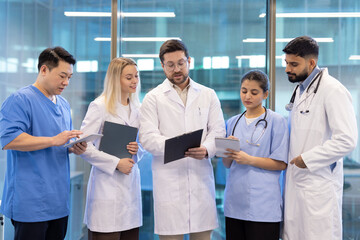 Medical team discussing patient chart in hospital corridor
