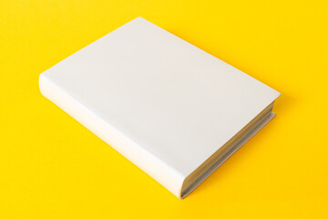 Closed generic blank book isolated on yellow background. Template mock up