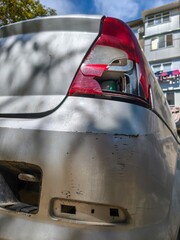 Car rear end with missing light and visible damaged parts of automobile exterior.