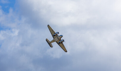 Steel biplane retro transportation plane on cloudy sky