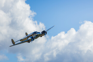 Steel biplane retro transportation plane on cloudy sky