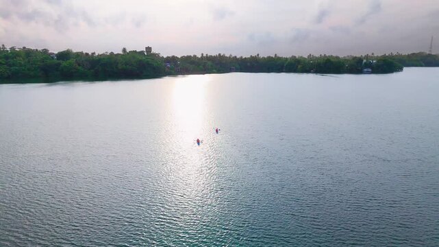 Evening Drone Push In of Two Kayaks Gliding Across a Shimmering Tropical Lagoon