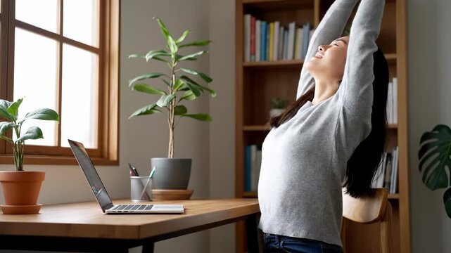 Woman stretches at desk at home office. A natural moment of calm and focus. Mindful break, ergonomic lifestyle, healthy habits.