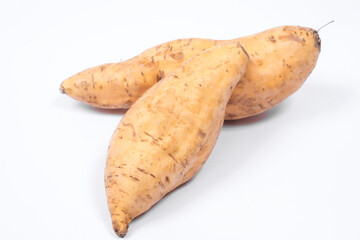 Two fresh Cilembu sweet potatoes isolated on white background, highlighting natural skin texture,...